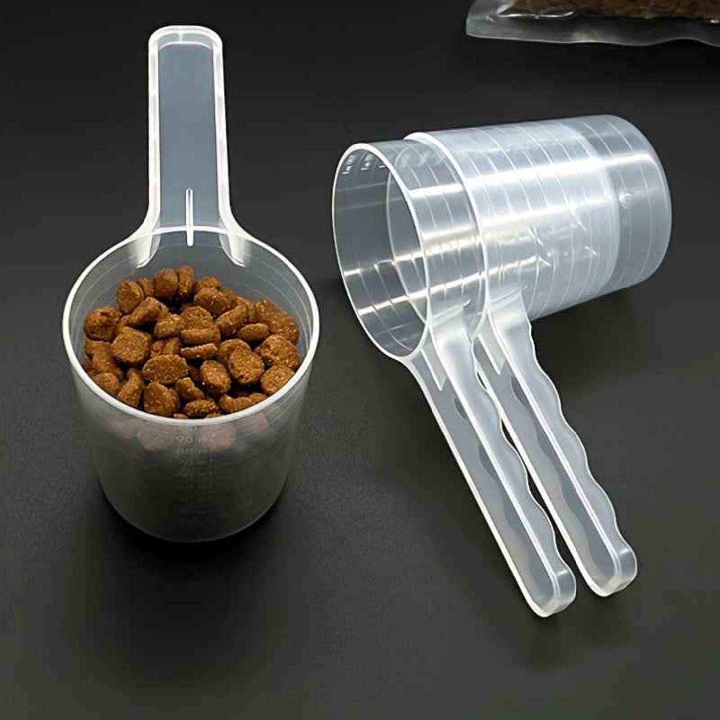 Cuillère de nourriture transparente pour chiens et chats avec marques de mesure. Plastique durable, manche ergonomique, facile à nettoyer. Idéale pour aliments secs, humides, compléments et lait en poudre